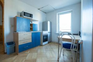 德鲁斯基宁凯Svečiuose pas Aldoną的厨房配有蓝色橱柜、桌子和椅子