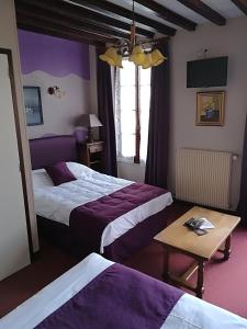 CreullyHostellerie Saint Martin- Logis Hôtel et Restaurant的酒店客房设有两张床和一张桌子。