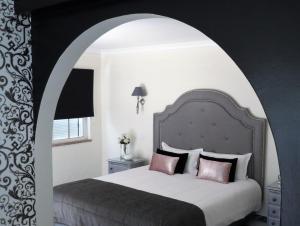 波尔蒂芒Villa Moments - Guest House的一间卧室设有一张大床和拱门
