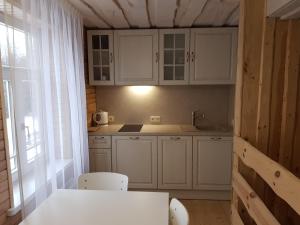 Dūmele泽德卡尼旅馆的厨房配有白色橱柜和桌椅