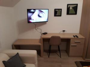 松博尔Apartment Mašić的客房设有一张桌子,墙上配有电视。