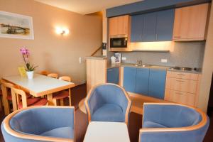 尼乌波特弗洛里尔纽波特酒店的带2把蓝色椅子和1张桌子的厨房以及带桌子的厨房