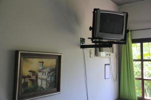 瓜拉派瑞Pousada Vista Bela的靠窗边墙上的电视