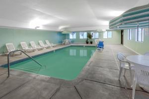 盖洛德盖洛德贝蒙特旅馆&套房酒店的游泳池配有椅子、桌子和桌椅