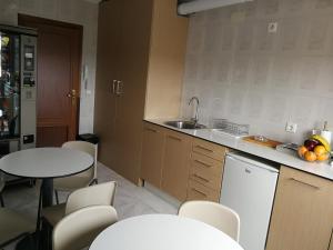 莱昂Hostal Cerecedo的厨房配有桌椅和水槽。