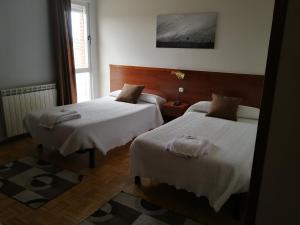 莱昂Hostal Cerecedo的酒店客房设有两张床和窗户。