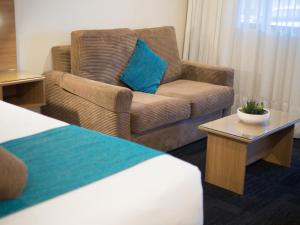 布里斯班Sunnybank Star Hotel的酒店客房,配有沙发和椅子