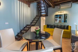 罗马斯帕达公寓式酒店的客厅配有玻璃桌和白色椅子