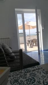 伊斯基亚Citara mare的一间卧室享有海滩美景,配有遮阳伞。
