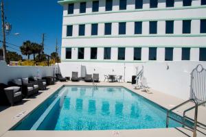 代托纳海滩The Streamline Hotel - Daytona Beach的一座带椅子的游泳池以及一座建筑