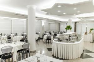 圣贝内代托-德尔特龙托尹朋里亚酒店的一间设有白色桌椅的用餐室