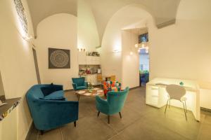那不勒斯白鹭酒店的客厅配有蓝色的椅子和桌子