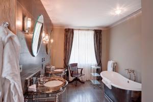 埃克塞特斯奥海之楼酒店的浴室配有2个盥洗盆、浴缸和浴缸。