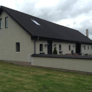 锡尔克堡Bøllingsø Feriehus的一间白色的房子,有黑色的屋顶和院子