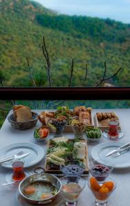 SazlıAssos Kartal Yuvasi Hotel的餐桌,盘子上放着食物和碗