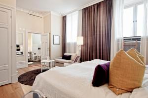 乌普萨拉安娜别墅酒店的酒店客房带一张大床和一把椅子