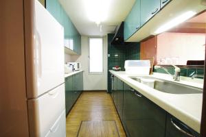 札幌AKKO宾馆的厨房铺有木地板,配有蓝色橱柜。