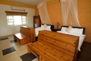 池上贤情玉致民宿的一间卧室设有两张床、一张长凳和一个窗户。