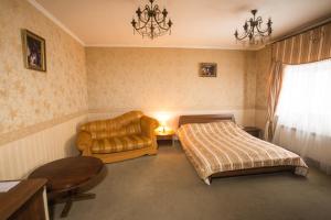 切尔诺夫策玛格纳特力士酒店的一间卧室配有一张床、一张沙发和一把椅子