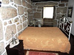 LajeosaCasa do Brigadeiro的一间卧室设有一张床和石墙