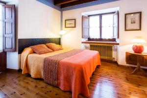 Vidiago卡瑟纳维迪雅阁公寓酒店的一间卧室配有一张带橙色毯子的床