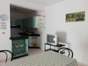 托雷莫泽Appartamento Alba vista spiaggia的一间厨房,内设桌子和一台电视机
