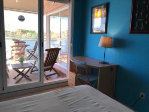 坎布里尔斯Apartamentos Llobregat的一间带一张床和一张书桌的卧室以及一个阳台