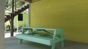 库尔克岛Barefoot Beach Belize的蓝色长椅,坐在黄色的墙上