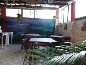 嘎林海斯港Swiss Flats的餐厅设有桌椅,墙上挂有绘画作品