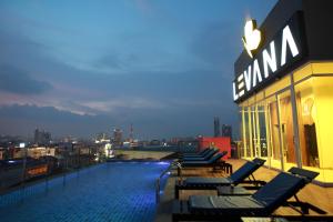 芭堤雅市中心Levana Pattaya Hotel - SHA Extra Plus的一座带椅子的建筑屋顶上的游泳池
