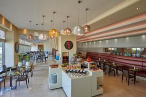 科威特科威特萨菲尔菲尼亚斯酒店的一间带桌椅的餐厅和一间酒吧