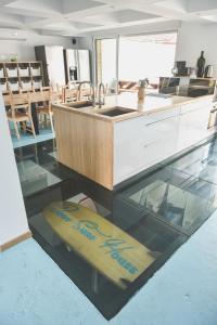 卡布勒通BodyGo Surfhouse的玻璃地板上的厨房,带有冲浪板