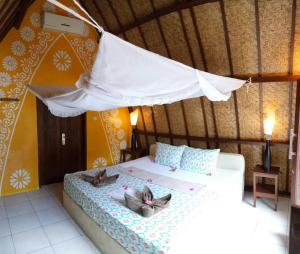 吉利特拉旺安鲁玛卡哈亚旅馆的一间卧室,配有一张床铺,上面有两只猫