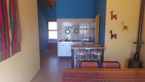 卡法亚特Casa en Cafayate的厨房拥有蓝色的墙壁,配有桌椅