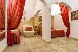 莫诺波利B&B Borgo San Martino的一间卧室设有两张床和红色窗帘