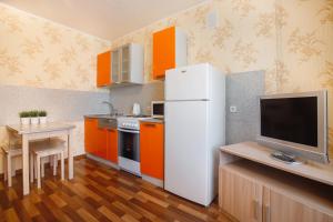 托木斯克Апартаменты на Савиных的厨房配有橙色橱柜和白色冰箱
