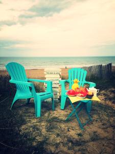 梅尔维尔弗朗瑟维尔普拉格LES PIEDS DANS L'EAU的海滩上的两把椅子和一张桌子及食物
