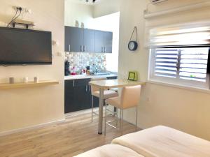 巴特亚姆Studio Apartment in Bat-Yam的客房设有带桌子和电视的厨房。