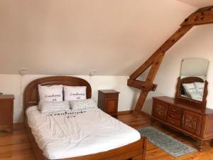 Beaumont-Hamelle clos du caribou的一间卧室配有一张带白色床单和镜子的床