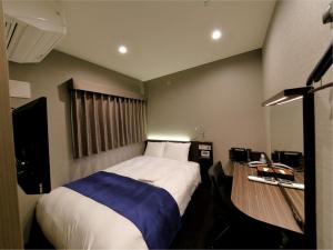 东京六本木艾克特酒店的一间小卧室,配有一张床和电视