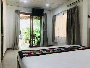 美奈阿南达度假村酒店的一间卧室设有一张床和一个大窗户
