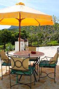 阿洛拉橙色度假屋的一张桌子和椅子,配有黄色雨伞