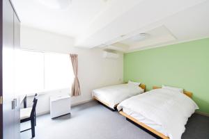 东京新大久保城市酒店的带窗户的客房内的两张床