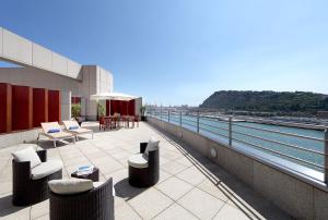 巴塞罗那欧洲之星玛莲娜大酒店的阳台配有桌椅,享有水景。