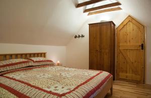 韦克斯福德Sutton Cottage的一间卧室配有一张床和一个木制橱柜