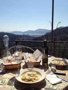 Valeriano Lunense阿格瑞托瑞斯摩奥里法阿祖拉酒店的餐桌,带食物盘和一瓶葡萄酒