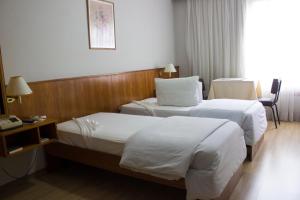 圣安娜-利弗拉门图Hotel Portal的酒店客房配有两张床和一张书桌