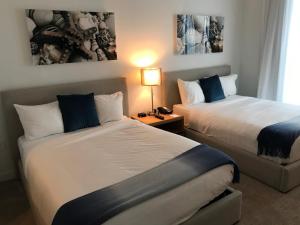 哈兰代尔海滩Beach Walk Resort De Lux Apartment的酒店客房,设有两张床和一盏灯