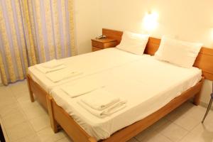 法里拉基迪米特拉酒店的一张带白色床单和白色毛巾的床