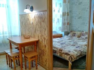利沃夫Apartment on Virmens'ka Street的一间卧室配有桌子、床和桌椅